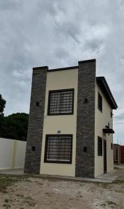 圣克莱门特雷图尤Casa Benicio - San Clemente del Tuyú的建筑的侧面有四个窗户