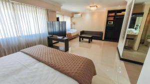 マル・デル・プラタにあるArgentino Hotelのベッドとリビングルームのある寝室