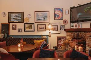 un restaurante con chimenea, mesa y sillas en Alcock & Brown Hotel, en Clifden