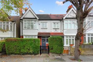 ein weißes Haus mit Hecken davor in der Unterkunft West London Home in Ealing