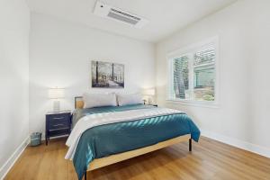 a white bedroom with a bed and a window at Lake Goodwin Retreat in Lake Goodwin