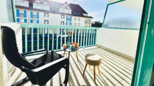 a balcony with a chair and a table and a building at L'air de Stella-Plage au coeur de la Station Balnéaire in Stella-Plage