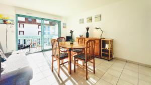 a dining room with a table and chairs and a window at L'air de Stella-Plage au coeur de la Station Balnéaire in Stella-Plage +11 photos