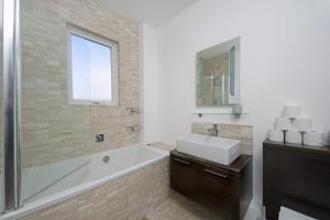 ein Badezimmer mit Badewanne und Waschbecken in der Unterkunft West London Home in Ealing + 11 Fotos