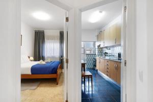 a hotel room with a bed and a kitchen at Happy House Central Apartment in Faro