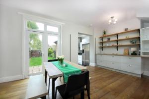 eine Küche und ein Esszimmer mit Tisch und Stühlen in der Unterkunft West London Home in Ealing