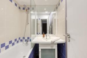 une salle de bain avec un lavabo, une douche et un miroir dans l'établissement Le Rustique - Porte de Versailles Apartment, à Issy-les-Moulineaux 22 autres photos