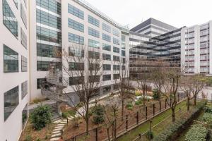 - une vue sur un bâtiment avec des arbres et des bâtiments dans l'établissement Le Rustique - Porte de Versailles Apartment, à Issy-les-Moulineaux