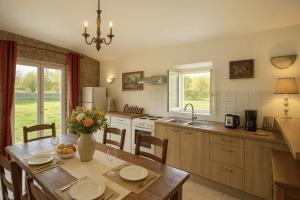 a kitchen with a wooden table with a vase of flowers at Le Clos de Vinzelle 12personnes Piscine in Vinzelles