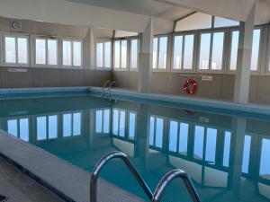 an empty swimming pool with blue water and windows at Eiffel Tower View & Pool in Paris