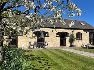 a brick house with a table and chairs in a yard at Stable Cottage, Oxfordshire in Oxford