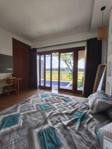 ein Schlafzimmer mit einem großen Bett und einer Glasschiebetür in der Unterkunft LaVella Villa Jogjakarta kolam renang pribadi in Godean