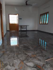an empty room with a concrete floor and a table at the epic villa in Mayiladuthurai +1 photo