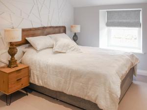 een slaapkamer met een groot bed en een raam bij Mill House - Uk50646 in Stithians +10 foto's
