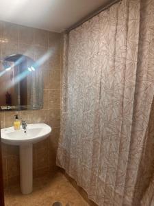 a bathroom with a sink and a shower curtain at Azor International Apartment II in Ponta Delgada