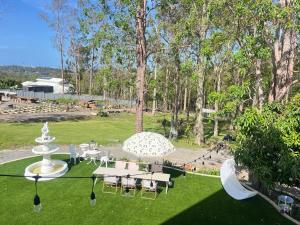 a park with tables and chairs and an umbrella at Tranquil Hideaway in Mudgeeraba in Gold Coast