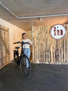 a woman standing next to a bike in a garage at I AM HOTEL Graz-Seiersberg in Graz