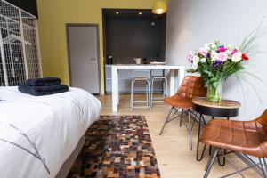 a bedroom with a bed and a table with flowers in a vase at Amsterdam House of Arts & Crafts in Amsterdam