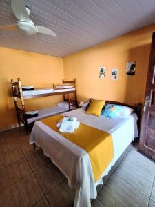 a bedroom with a large bed and a bunk bed at Pousada Solar Tropical in Saquarema