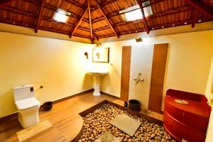 a bathroom with a toilet and a sink in a room at Emerald Isle in Alleppey