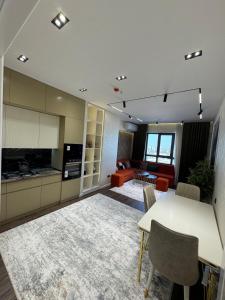 a kitchen and living room with a table and chairs at Luxury apartment at 16th floor of Akay city in Tashkent near metro in Salor Bekati