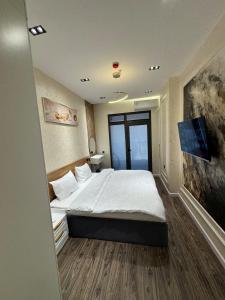 a bedroom with a bed and a flat screen tv at Luxury apartment at 16th floor of Akay city in Tashkent near metro in Salor Bekati