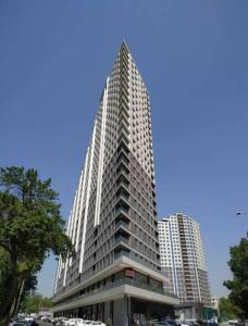 a tall building with cars parked in front of it at Luxury apartment at 16th floor of Akay city in Tashkent near metro in Salor Bekati