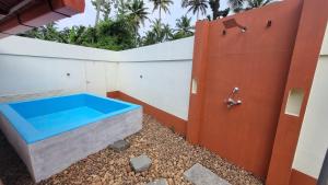 a bathtub in the backyard of a house with a door at Emerald Isle in Alleppey