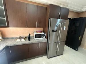 a kitchen with a refrigerator and a microwave on a counter at Dar Salma in Tangier