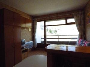 a living room with a large window and a television at Studio confortable pour 4 pers, accès direct galerie et pistes, ascenseur - FR-1-602-75 in Arette +2 photos