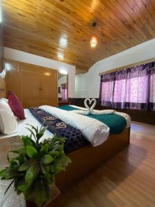 a bedroom with a large bed in a room at !!The Valley View Hill-Top Heights & Open Rooftop Cafe !! Bonfire !! Family Hotel Near To Mall Road 100Mtr!! in Vashisht