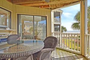 a patio with a table and chairs on a balcony at PC202E: 202E Port O'Call in Isle of Palms