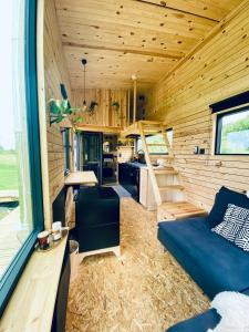 a tiny house with a blue couch and a kitchen at Tinyhouse au coeur d'un vignoble in Floreffe
