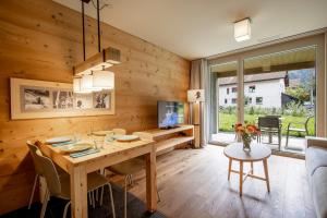 a dining room with a wooden wall at SWISSPEAK Resorts by Pierre & Vacances Premium Meiringen in Meiringen
