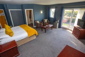 科尔福德贝尔斯酒店的卧室里有一张床，床上铺着一条黄色的毯子