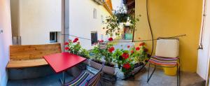 a balcony with a table and a bench and flowers at Chasina Rosa in Scuol