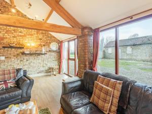 a living room with leather furniture and a brick wall at The Tack Rooms - Uk37520 in Routh