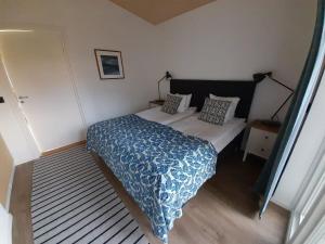 a bedroom with a bed with a blue comforter at Studio apartment in Kivik in Kivik