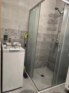 a shower with a glass door in a bathroom at Апартамент Славяна in Velingrad