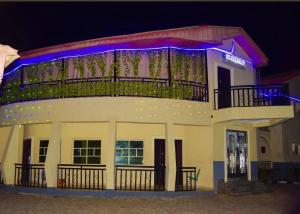 a building with a balcony on top of it at night at Gracefield hotel & suites in Eggan