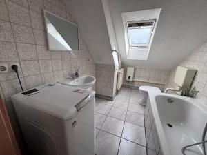 ein Badezimmer mit Waschbecken, Badewanne und Toilette in der Unterkunft AriProp Kretzschau Village Apartment in Kretzschau