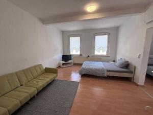 Zimmer mit Sofa, Bett und Fenstern in der Unterkunft AriProp Kretzschau Village Apartment in Kretzschau