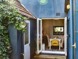 a small room with a table and a yellow chair at Beval Cottage in Abergavenny
