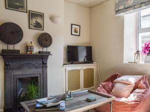 a living room with a fireplace and a tv at Beval Cottage in Abergavenny