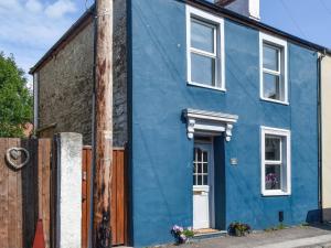 a blue house with a white door on a street at Beval Cottage in Abergavenny +13 photos
