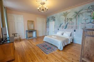 ein Schlafzimmer mit einem Bett und einem Kronleuchter in der Unterkunft La Léontine in Abbeville