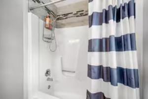 a bathroom with a blue and white shower curtain at Spacious 3 Bedroom in Cary +22 photos
