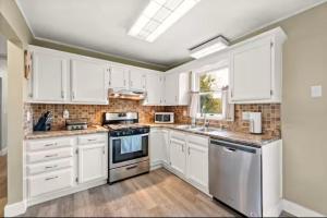 a kitchen with white cabinets and white appliances at Spacious 3 Bedroom in Cary