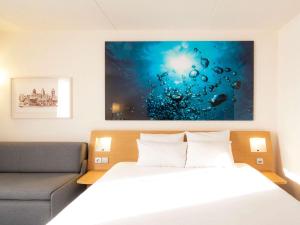ein Schlafzimmer mit einem Bett und einem Gemälde an der Wand in der Unterkunft Novotel Antwerpen - Ekeren in Antwerpen + 118 Fotos