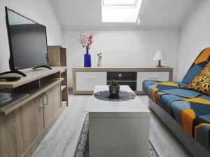 "ハルカーニャ"にあるEra Apartmanのソファとテレビのあるリビングルーム